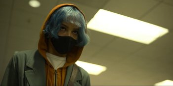 Movie still from “Kimi” (2022), directed by Steven Soderbergh – A person with blue hair wearing a mask; Close Up shot, Low angle
