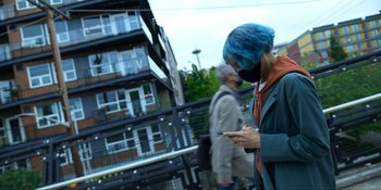 Movie still from “Kimi” (2022), directed by Steven Soderbergh – A woman with blue hair looking at her cell phone; Medium shot, Low angle