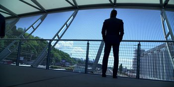 Movie still from “Kimi” (2022), directed by Steven Soderbergh – A man in a suit standing in front of a fence; Wide shot, Low angle