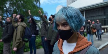 Movie still from “Kimi” (2022), directed by Steven Soderbergh – A person with blue hair and a face mask; Close Up shot, Low angle
