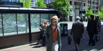 Movie still from “Kimi” (2022), directed by Steven Soderbergh – A woman walking down the street in a green jacket; Wide shot, High angle