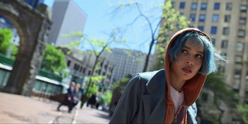Movie still from “Kimi” (2022), directed by Steven Soderbergh – A young man with blue hair is walking down the street; Close Up shot, Low angle