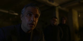 Movie still from “Kimi” (2022), directed by Steven Soderbergh – A man in a dark room looking at the camera; Close Up shot, Over the shoulder angle