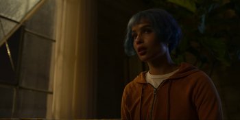 Movie still from “Kimi” (2022), directed by Steven Soderbergh – A person with blue hair is standing in a room; Close Up shot, Over the shoulder angle