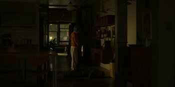 Movie still from “Kimi” (2022), directed by Steven Soderbergh – A man laying on the floor in a room; Wide shot, High angle