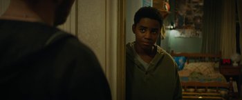 Movie still from “Kin” (2018), directed by Josh Baker – A young man looking at himself in the mirror; Close Up shot, Over the shoulder angle