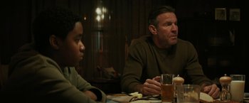 Movie still from “Kin” (2018), directed by Josh Baker – A man sitting at a dinner table with a young boy; Medium shot, Over the shoulder angle