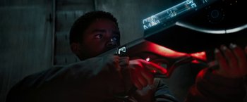 Movie still from “Kin” (2018), directed by Josh Baker – A man is holding a gun in the dark; Close Up shot, Low angle