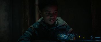Movie still from “Kin” (2018), directed by Josh Baker – A young boy is looking at a cell phone; Close Up shot, Over the shoulder angle