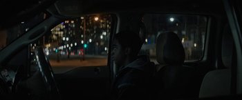 Movie still from “Kin” (2018), directed by Josh Baker – A man sitting in the back seat of a car at night; Close Up shot, Over the shoulder angle