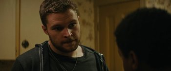 Movie still from “Kin” (2018), directed by Josh Baker – A person wearing a black shirt; Close Up shot, Over the shoulder angle