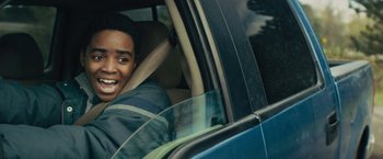 Movie still from “Kin” (2018), directed by Josh Baker – A man sitting in the driver's seat of a blue car; Close Up shot, Over the shoulder angle