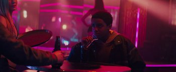 Movie still from “Kin” (2018), directed by Josh Baker – A man sitting at a table with a drink in front of him; Medium shot, Over the shoulder angle
