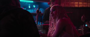 Movie still from “Kin” (2018), directed by Josh Baker – A woman sitting at a table in front of a microphone; Close Up shot, Over the shoulder angle