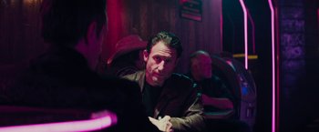 Movie still from “Kin” (2018), directed by Josh Baker – A man sitting at a table in front of other people; Medium shot, Over the shoulder angle