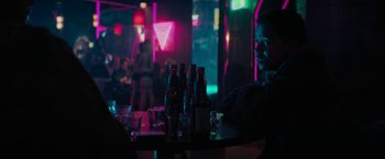 Movie still from “Kin” (2018), directed by Josh Baker – A man sitting at a table in front of a bunch of drinks; Medium shot, Over the shoulder angle