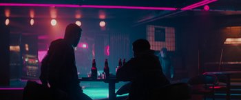 Movie still from “Kin” (2018), directed by Josh Baker – Two men sitting at a table with beer bottles; Wide shot, Over the shoulder angle