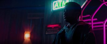 Movie still from “Kin” (2018), directed by Josh Baker – A man standing in front of a neon atm sign; Close Up shot, Low angle