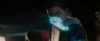 Movie still from “Kin” (2018), directed by Josh Baker – A young man with a neon light around his face; Close Up shot, Over the shoulder angle