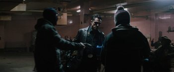 Movie still from “Kin” (2018), directed by Josh Baker – A group of people standing in a room shaking hands; Medium shot, Over the shoulder angle