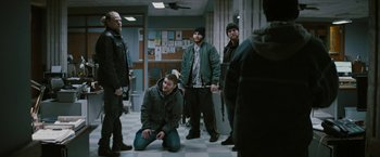 Movie still from “Kin” (2018), directed by Josh Baker – A group of men standing around in a room; Wide shot, Over the shoulder angle