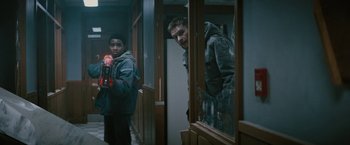 Movie still from “Kin” (2018), directed by Josh Baker – A man looking into a mirror while holding a camera; Medium shot, Low angle