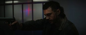 Movie still from “Kin” (2018), directed by Josh Baker – A person leaning on a wall; Close Up shot, Low angle