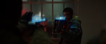 Movie still from “Kin” (2018), directed by Josh Baker – A young boy holding a video game remote control; Medium shot, Low angle