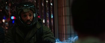 Movie still from “Kin” (2018), directed by Josh Baker – A person wearing a green jacket and a helmet; Close Up shot, Over the shoulder angle