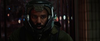 Movie still from “Kin” (2018), directed by Josh Baker – A man wearing a helmet and a green jacket; Close Up shot, Over the shoulder angle