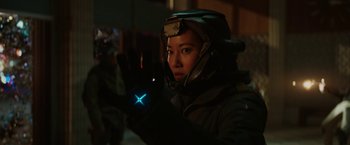 Movie still from “Kin” (2018), directed by Josh Baker – A person wearing a helmet and gloves is holding a glowing object; Close Up shot, Over the shoulder angle