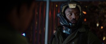 Movie still from “Kin” (2018), directed by Josh Baker – A man wearing a helmet is standing in front of a wall; Close Up shot, Over the shoulder angle