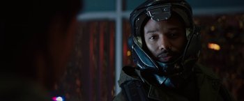 Movie still from “Kin” (2018), directed by Josh Baker – A man wearing a motorcycle helmet in front of a window; Close Up shot, Over the shoulder angle