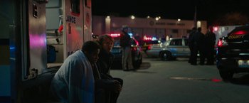 Movie still from “Kin” (2018), directed by Josh Baker – Two people sitting on the side of the street; Wide shot, Over the shoulder angle