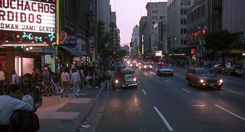 Movie still from “Kindergarten Cop” (1990), directed by Ivan Reitman – A busy city street filled with cars and pedestrians; Extreme Wide shot, High angle