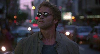 Movie still from “Kindergarten Cop” (1990), directed by Ivan Reitman – A person wearing sunglasses on a city street; Close Up shot, Low angle