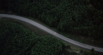 Movie still from “Kindergarten Cop” (1990), directed by Ivan Reitman – An aerial view of a car driving down the road; Extreme Wide shot, Overhead angle