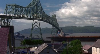 Movie still from “Kindergarten Cop” (1990), directed by Ivan Reitman – A boat is in the water under a bridge; Extreme Wide shot, Low angle