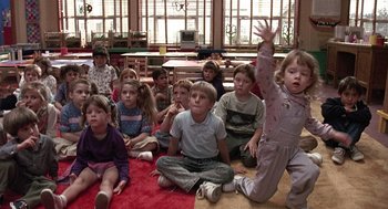 Movie still from “Kindergarten Cop” (1990), directed by Ivan Reitman – A group of children sitting on the floor in a room; Medium shot, High angle