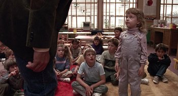 Movie still from “Kindergarten Cop” (1990), directed by Ivan Reitman – A group of children sitting on the floor in a room; Medium shot, Over the shoulder angle