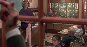 Movie still from “Kindergarten Cop” (1990), directed by Ivan Reitman – A woman sitting on a bench next to a girl; Medium shot, Over the shoulder angle