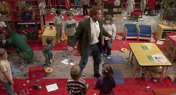 Movie still from “Kindergarten Cop” (1990), directed by Ivan Reitman – A group of children and a man standing in a room; Wide shot, High angle