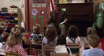 Movie still from “Kindergarten Cop” (1990), directed by Ivan Reitman – A group of children sitting in front of a man; Wide shot, Over the shoulder angle