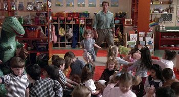 Movie still from “Kindergarten Cop” (1990), directed by Ivan Reitman – A group of children sitting in a room with an adult; Wide shot, Over the shoulder angle