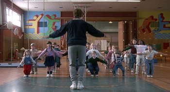 Movie still from “Kindergarten Cop” (1990), directed by Ivan Reitman – A group of children in a gym doing different moves; Wide shot, Low angle