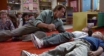 Movie still from “Kindergarten Cop” (1990), directed by Ivan Reitman – A group of people sitting on the ground; Wide shot, Overhead angle