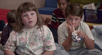 Movie still from “Kindergarten Cop” (1990), directed by Ivan Reitman – A group of children sitting next to each other; Medium shot, High angle