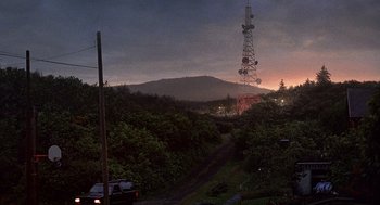 Movie still from “Kindergarten Cop” (1990), directed by Ivan Reitman – A car is driving down a road near a telephone pole; Extreme Wide shot, High angle