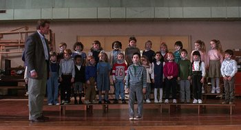 Movie still from “Kindergarten Cop” (1990), directed by Ivan Reitman – A group of children standing in front of each other on a stage; Wide shot, Low angle