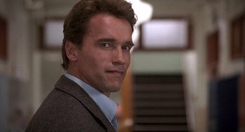 Movie still from “Kindergarten Cop” (1990), directed by Ivan Reitman – A person wearing a suit and tie; Close Up shot, Low angle